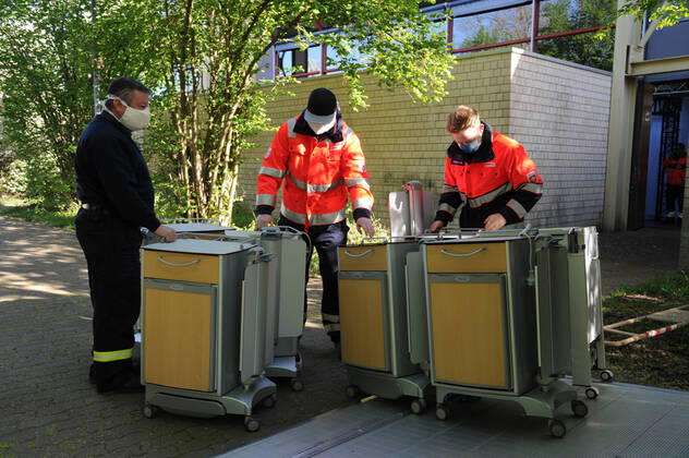 Die Sporthalle In den Fliesen in Saarlouis wird am Mittwoch (15.04.2020) wegen der Corona Krise zu einem Versogungszentrum umgebaut. Ingsgesamt 105 Betten werden in den kommenden Tagen von Hilfsorganisationen aufgestellt. Die Hilfskräfte von DRK, Malteser, THW, DRLG, BRH und der Feuerwehr Wadgassen bringen unter anderem Betten und Nachttische in die Sporthalle, wo diese dann aufgestellt und zum Teil aufgebaut werden müssen. Einige Betten kommen aus saarländischen Pflegeheimen. Heute werden 54 Pflegebetten aufgebaut. Geplant sind Dusch- und Toilettencontainer, die voraussichtlich morgen geliefert und angeschlossen werden. Wir sind lieber gut auf den Notfall vorbereitet , so Andreas Schorn, Mitarbeiter der Unterstützungsgruppe vom DRK Saarlouis.