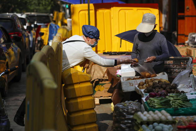 (200417) -- WUHAN, April 17, 2020 -- A woman buys vegetables in Wuhan, capital of central China s Hubei Province, April 16, 2020. As the coronavirus epidemic wanes, life returns to normal in Wuhan gradually. ) CHINA-WUHAN-DAILY LIFE-RETURNING TO NORMAL(CN) ShenxBohan 