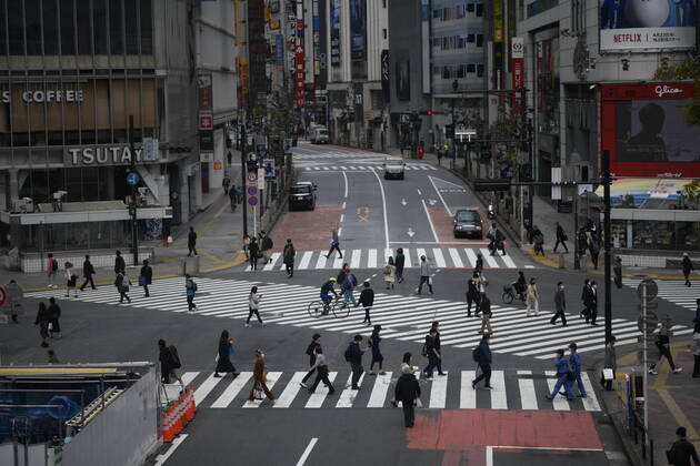 TOKYO, JAPAN - APRIL 17: Commuters wearing face mask were seen crossing the street near JR Shibuya Station in Tokyo on Friday, April 17, 2020. The Japanese government decided to expand the current areas under a state of emergency to nationwide, as the Covid-19 coronavirus outbreak continues to spread throughout the country. (Photo: Richard Atrero de Guzman AFLO) (125429999)