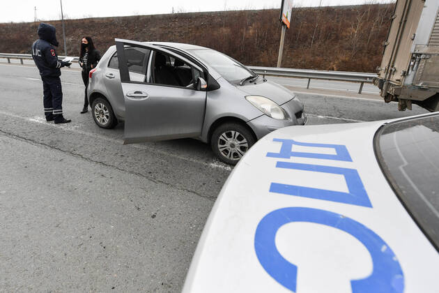 VLADIVOSTOK, RUSSIA - APRIL 17, 2020: A traffic police officer carries out an ID check at the entrance to Russky Island in the city of Vladivostok in Russia s Far East during the pandemic of the novel coronvirus disease (COVID-19). Vladivostok s traffic police have set up a checkpoint at the approach to the bridge to stop vehicles and see if drivers and cyclists have permission to travel to Russky Island during the lockdown. Vladivostok s authorities have restricted access to Russky Island and a few smaller islands -- popular weekend retreats -- to prevent people from violating lockdown measures. Only those who live, work or study on the islands are allowed to travel. Since 31 March 2020, the Primorye Territory, including Vladivostok, has been on lockdown to counter the spread of the infection. As of 17 April 2020, the Primorye Territory  TS0D6116