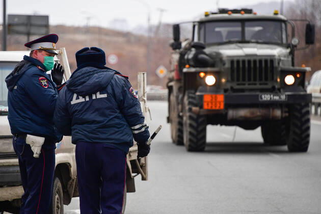 VLADIVOSTOK, RUSSIA - APRIL 17, 2020: Traffic police officers carry out ID checks at the entrance to Russky Island in the city of Vladivostok in Russia s Far East during the pandemic of the novel coronvirus disease (COVID-19). Vladivostok s traffic police have set up a checkpoint at the approach to the bridge to stop vehicles and see if drivers and cyclists have permission to travel to Russky Island during the lockdown. Vladivostok s authorities have restricted access to Russky Island and a few smaller islands -- popular weekend retreats -- to prevent people from violating lockdown measures. Only those who live, work or study on the islands are allowed to travel. Since 31 March 2020, the Primorye Territory, including Vladivostok, has been on lockdown to counter the spread of the infection. As of 17 April 2020, the Primorye Territory (inc  TS0D611A