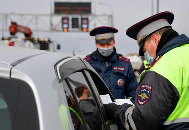 VLADIVOSTOK, RUSSIA - APRIL 17, 2020: Traffic police officers carry out ID checks at the entrance to Russky Island in the city of Vladivostok in Russia s Far East during the pandemic of the novel coronvirus disease (COVID-19). Vladivostok s traffic police have set up a checkpoint at the approach to the bridge to stop vehicles and see if drivers and cyclists have permission to travel to Russky Island during the lockdown. Vladivostok s authorities have restricted access to Russky Island and a few smaller islands -- popular weekend retreats -- to prevent people from violating lockdown measures. Only those who live, work or study on the islands are allowed to travel. Since 31 March 2020, the Primorye Territory, including Vladivostok, has been on lockdown to counter the spread of the infection. As of 17 April 2020, the Primorye Territory (inc  TS0D6123