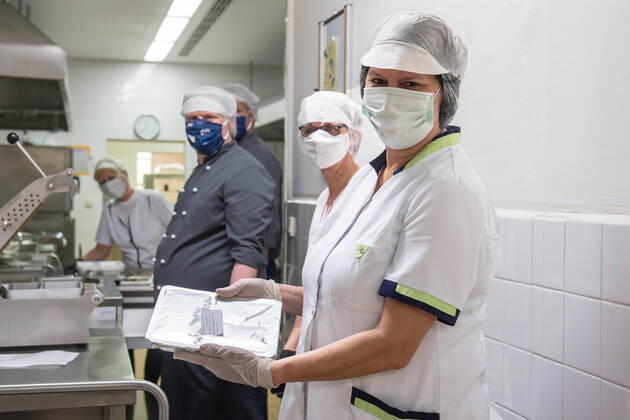 Mitarbeiter der Kueche Bisamkiez am Freitag (17.04.2020) beim abfuellen und verpacken der Essensportionen in Potsdam. Brandenburgs Landeshauptstadt Potsdam versorgt in der Corona-Krise sozial benachteiligte Kinder mobil mit Mittagessen. Inzwischen werden Mahlzeiten fuer fast 1.000 Kinder in 476 Haushalten geliefert, die wegen der Anti-Corona-Massnahmen nicht in die Kita oder zur Schule gehen duerfen. Die Stadt arbeitet bei der Versorgung der Kinder derzeit mit der Potsdamer Tafel, vier Caterern und zwei Fahrdiensten des Deutschen Roten Kreuzes und einem lokalen Anbieter zusammen. (Siehe epd-Meldung vom 17.04.2020) Mobiles Mittagessen fuer fast 1.000 arme Kinder in Potsdam
