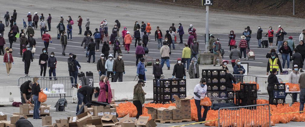 The San Francisco-Marin Food Bank distributes bags of food to lined up people in the parking lot of the Cow Palace in Daly City, California on Friday, April 17, 2020. Local food banks have moved into high gear as the Coronavirus has hit the food insecure especially hard.  SXP2020041605 TERRYxSCHMITT