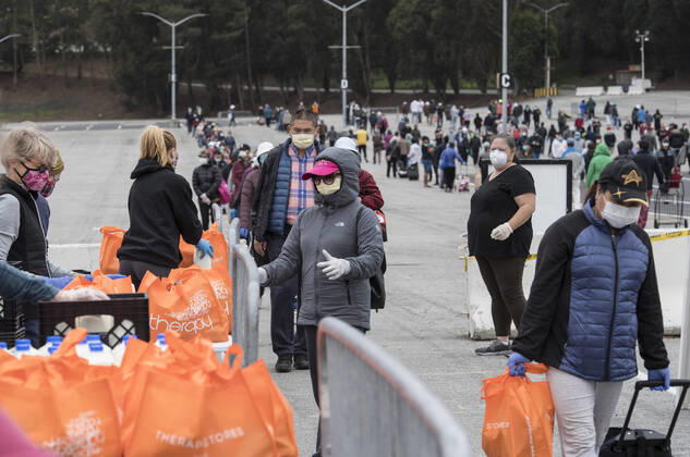 People line up to receive bags of food from the San Francisco-Marin Food Bank in the parking lot of the Cow Palace in Daly City, California on Friday, April 17, 2020. Local food banks have moved into high gear as the Coronavirus has hit the food insecure especially hard.  SXP2020041612 TERRYxSCHMITT