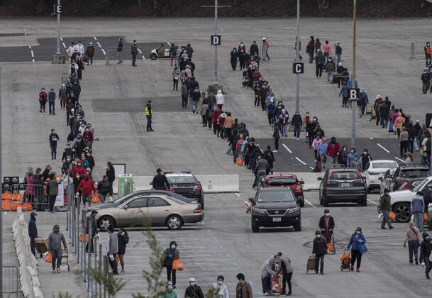 People line up to receive bags of food from the San Francisco-Marin Food Bank in the parking lot of the Cow Palace in Daly City, California on Friday, April 17, 2020. Local food banks have moved into high gear as the Coronavirus has hit the food insecure especially hard.  SXP2020041613 TERRYxSCHMITT