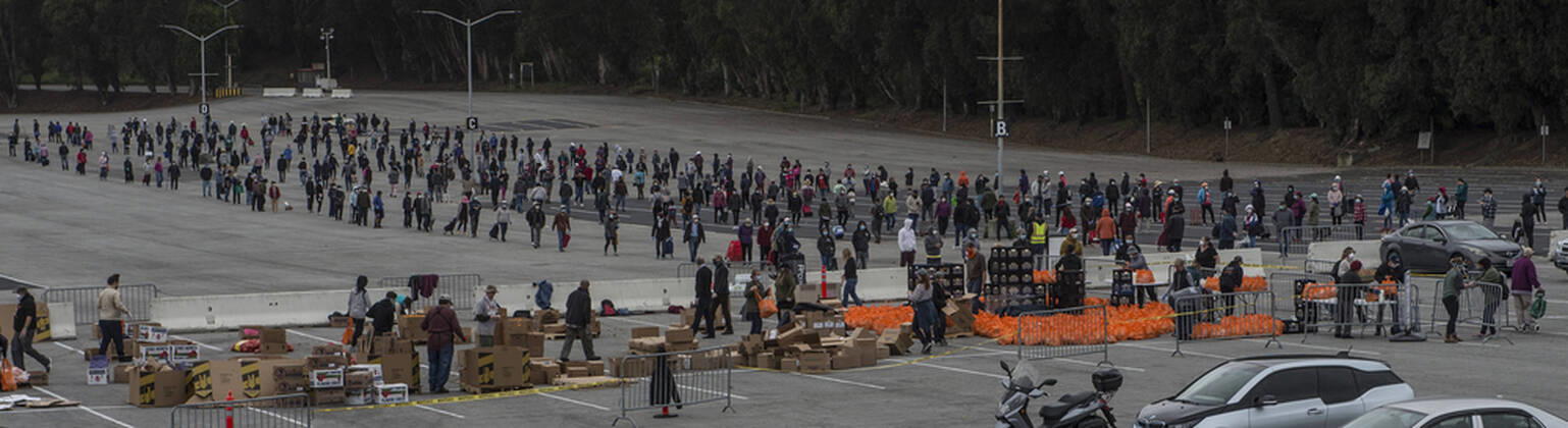 People line up to receive bags of food from the San Francisco-Marin Food Bank in the parking lot of the Cow Palace in Daly City, California on Friday, April 17, 2020. Local food banks have moved into high gear as the Coronavirus has hit the food insecure especially hard.  SXP2020041617 TERRYxSCHMITT