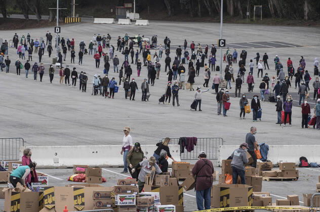 The San Francisco-Marin Food Bank distributes bags of food to lined up people in the parking lot of the Cow Palace in Daly City, California on Friday, April 17, 2020. Local food banks have moved into high gear as the Coronavirus has hit the food insecure especially hard.  SXP2020041623 TERRYxSCHMITT