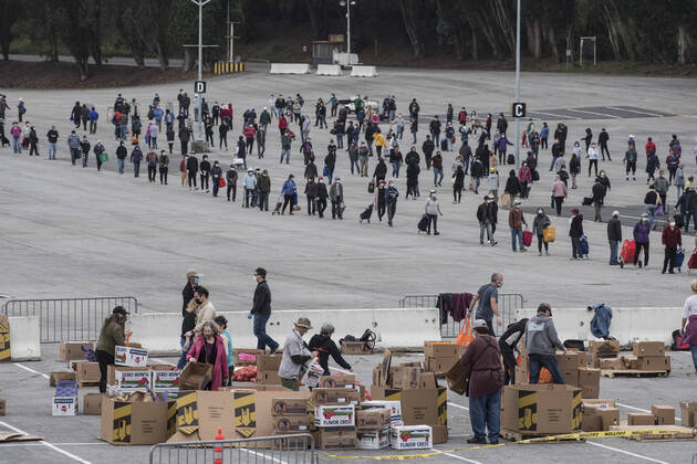 The San Francisco-Marin Food Bank distributes bags of food to lined up people in the parking lot of the Cow Palace in Daly City, California on Friday, April 17, 2020. Local food banks have moved into high gear as the Coronavirus has hit the food insecure especially hard.  SXP2020041624 TERRYxSCHMITT