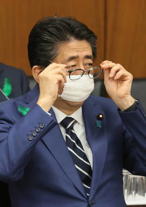 News Bilder des Tages April 17, 2020, Tokyo, Japan - Japanese Prime Minister Shinzo Abe wearing a face mask adjusts his glasses as he listens to a question at Lower House s health, labour and welfare committee session at the National Diet in Tokyo on Friday, April 17, 2020. Abe expanded a state of emergency across Japan to prevent outbreak of the new coronavirus on April 17.  (125461119)