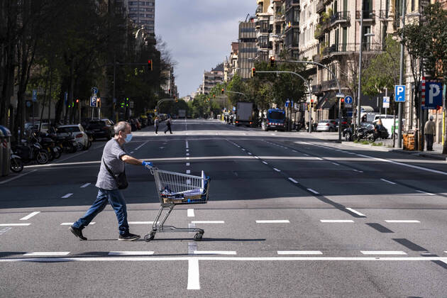 April 17, 2020, Barcelona, Catalonia, Spain: A man crosses the deserted Aragon street pushing a supermarket cart during confinement. Barcelona overcomes a month of home confinement and social distancing. It is already 34 days since March 15th when the Spanish Government decreed a state of emergency. Only essential services are functioning. Barcelona Spain - ZUMAs197 20200417_zaa_s197_061 Copyright: xPacoxFreirex