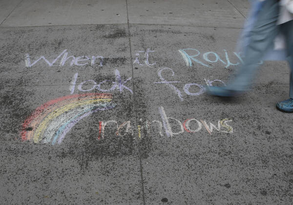 A healthcare worker walks by an uplifting message written in colored chalk on the sidewalk of NYU Langone hospital moments before FDNY firefighters, NYPD police officers and pedestrians applaud and show their gratitude to medical staff and essential workers on the front lines of the coronavirus pandemic in New York City on Friday, April 17, 2020. The city s coronavirus death toll continued to climb with over 700 new COVID-19 fatalities bringing the total to over 12,000 to date.  NYP20200417114 JOHNxANGELILLO