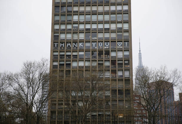 The words Thank You is spelled out in the windows of a building directly across from NYU Langone hospital when FDNY firefighters, NYPD police officers and pedestrians applaud and show their gratitude to medical staff and essential workers on the front lines of the coronavirus pandemic in New York City on Friday, April 17, 2020. The city s coronavirus death toll continued to climb with over 700 new COVID-19 fatalities bringing the total to over 12,000 to date.  NYP20200417113 JOHNxANGELILLO