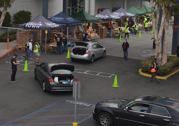 Los Angeles County Federation of Labor members stage a drive-.thru mobile food pantry to help feed thousands of South L.A. residents during the COVID-19 pandemic at the Baldwin Hills Crenshaw mall in Los Angeles on Friday, April 17, 2020. The effort is expected to feed over 2,500 families, 10,000 individuals.  LAP2020041717 JIMxRUYMEN