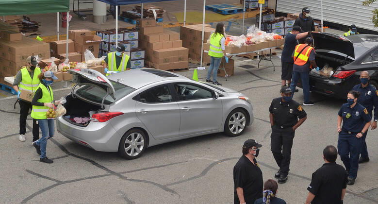 Los Angeles County Federation of Labor members stage a drive-.thru mobile food pantry to help feed thousands of South L.A. residents during the COVID-19 pandemic at the Baldwin Hills Crenshaw mall in Los Angeles on Friday, April 17, 2020. The effort is expected to feed over 2,500 families, 10,000 individuals.  LAP2020041707 JIMxRUYMEN