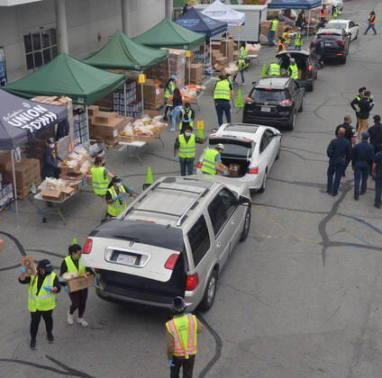 Los Angeles County Federation of Labor members stage a drive-.thru mobile food pantry to help feed thousands of South L.A. residents during the COVID-19 pandemic at the Baldwin Hills Crenshaw mall in Los Angeles on Friday, April 17, 2020. The effort is expected to feed over 2,500 families, 10,000 individuals.  LAP2020041711 JIMxRUYMEN
