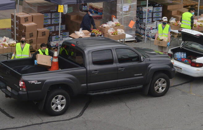 Los Angeles County Federation of Labor members stage a drive-thru mobile food pantry to help feed thousands of South L.A. residents during the COVID-19 pandemic at the Baldwin Hills Crenshaw mall in Los Angeles on Friday, April 17, 2020. The effort is expected to feed over 2,500 families, 10,000 individuals.  LAP2020041721 JIMxRUYMEN