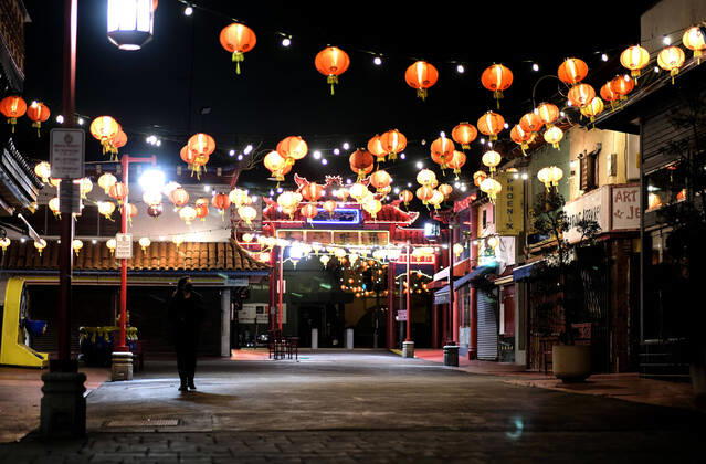 April 17, 2020, Los Angeles, California, U.S: A woman wearing a mask walks through the Chinatown Plaza Friday night April 18, 2020 in Los Angeles Los Angeles U.S. - ZUMAc68_ 20200417_zaf_c68_003 Copyright: xRingoxChiux