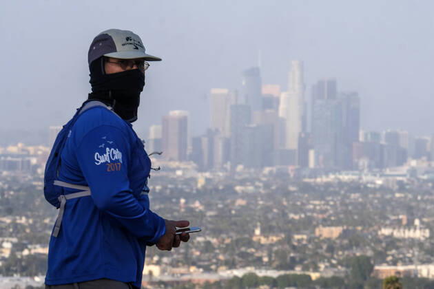 April 17, 2020, Los Angeles, California, U.S: A man wearing a mask with downtown Los Angeles skyline in background is seen at Kenneth Hahn State Recreation Area Friday April 17, 2020 in Los Angeles. Los Angeles U.S. - ZUMAc68_ 20200417_zaf_c68_004 Copyright: xRingoxChiux