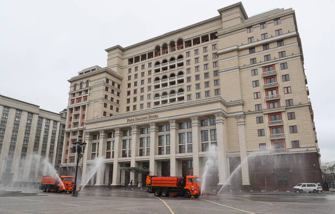 MOSCOW, RUSSIA - APRIL 18, 2020: Utility machines disinfecting the pavement of Okhotny Ryad Street with a special solution recommended by the Russian Federal Service for Surveillance on Consumer Rights Protection and Human Wellbeing (Rospotrebnadzor) amid the COVID-19 coronavirus pandemic. Alexander Shcherbak TASS  TS0D630B