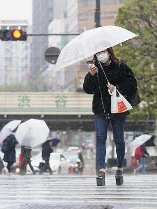 New coronavirus People walk in Tokyo s Shibuya entertainment district on April 18, 2020, wearing masks amid concerns over the new coronavirus. 