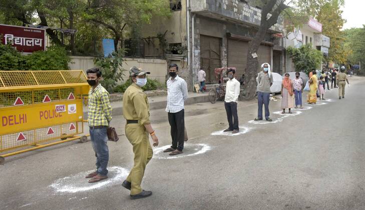 NEW DELHI, INDIA - APRIL 14: People queue to collect food distributed by the Delhi government during the lockdown, at Gandhi Nagar, on April 14, 2020 in New Delhi, India. (Photo by Sushil Kumar Hindustan Times ) Government And NGOs Provide Food To Homeless And Poor Amid Lockdown To Prevent Covid-19