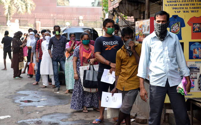MUMBAI, INDIA - APRIL 14: Residents of Dharavi lineup at rationing office for the food items, during the nationwide lockdown, imposed in the wake of the coronavirus pandemic, on April 14, 2020 in Mumbai, India. (Photo by Satish Bate Hindustan Times ) Government And NGOs Provide Food To Homeless And Poor Amid Lockdown To Prevent Covid-19