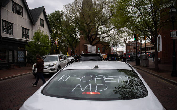 A car is seen as people participate in a car protest to reopen Maryland and end the stay at home order imposed during the Coronavirus COVID-19 pandemic, near the state capitol building in Annapolis, Maryland on Saturday, April 18, 2020.  WAP20200418306 KEVINxDIETSCH