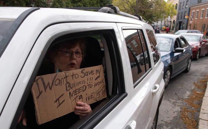 Drivers in vehicles line up during a protest to reopen Maryland and end the stay at home order imposed during the Coronavirus COVID-19 pandemic, near the state capitol building in Annapolis, Maryland on Saturday, April 18, 2020. Drivers circled Annapolis hoking their horns and calling for Gov. Larry Hogan (R-MD) to end the stay at home order.  WAP20200418319 KEVINxDIETSCH