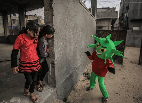 April 18, 2020, Nuseirat Camp, The Gaza Strip, Palestine: Clown wear coronavirus doll in Nuseirat camp in central of the Gaza strip, to awareness kids about the diseases. Nuseirat Camp Palestine - ZUMAq100 20200418_zaa_q100_003 Copyright: xAbedxAlrahmanxAlkahloutx