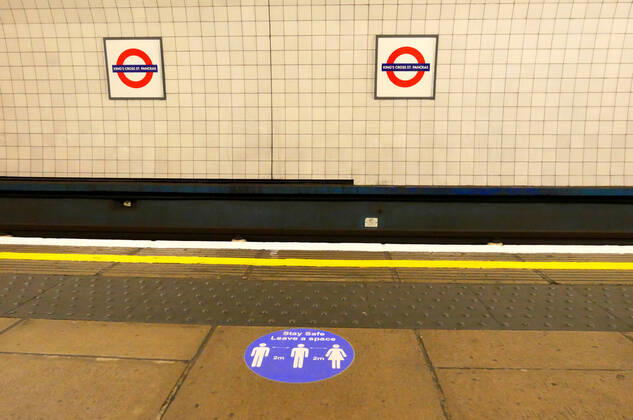 Day Twenty Six of Lockdown in London. Stickers on the platform advising of social distancing at London Kings Cross underground station on a very quiet Saturday as the country is on lockdown due to the COVID-19 Coronavirus pandemic. People are not allowed to leave home except for minimal food shopping, medical treatment, exercise - once a day, and essential work. COVID-19 Coronavirus lockdown, London, UK, on April 18, 2020 