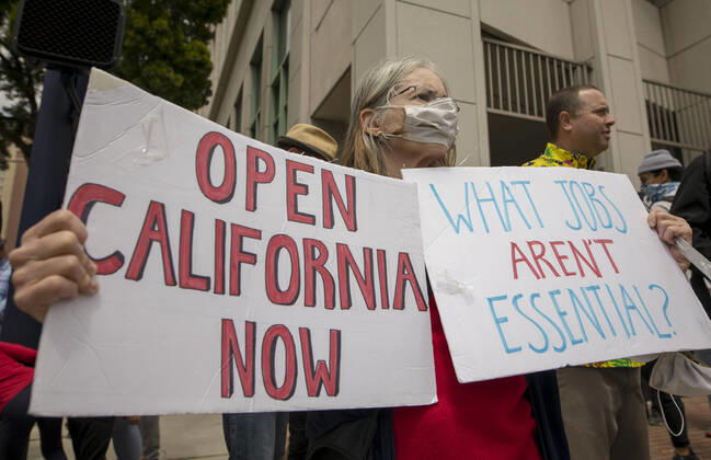 April 18, 2020, San Diego, California, US: Protesters at a Liberate San Diego rally in downtown San Diego on Saturday waved signs and held banners complaining that they wanted the state to lift its stay at home order, a measure meant to reduce the spread of the coronavirus. The event was clearly political, with an overwhelming amount of signs and banners supporting President Trump. San Diego US - ZUMAp23_ 20200418_zaf_p23_004 Copyright: xDavidxPollerx