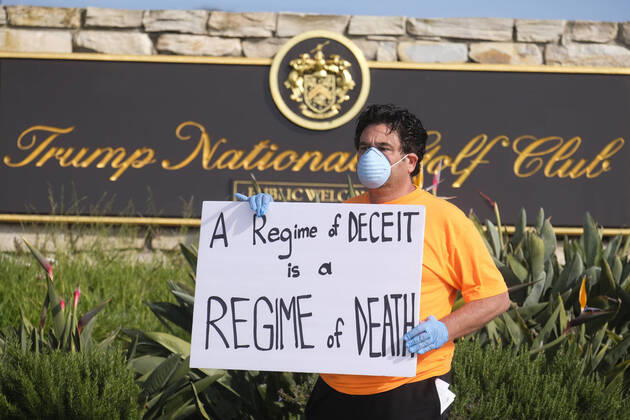 April 18, 2020, Los Angeles, California, U.S: A demonstrator holds a sign outside Trump National Golf Club Los Angeles in protest against U.S. President Donald Trump s response to the coronavirus disease (COVID-19) pandemic, in Rancho Palos Verdes, California, April 18, 2020. Los Angeles U.S. - ZUMAc68_ 20200418_zaf_c68_002 Copyright: xRingoxChiux