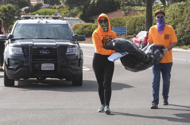April 18, 2020, Los Angeles, California, U.S: Demonstrators carry a fake body bag outside Trump National Golf Club Los Angeles in protest against U.S. President Donald Trump s response to the coronavirus disease (COVID-19) pandemic, in Rancho Palos Verdes, California, April 18, 2020. Los Angeles U.S. - ZUMAc68_ 20200418_zaf_c68_014 Copyright: xRingoxChiux