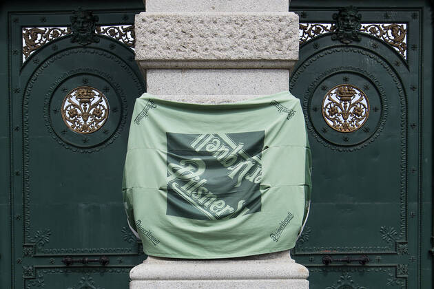 Pilsner Urquell Brewery main gate with a protection face mask is seen on April 18, 2020, in Pilsen, Czech Republic. The brewery bottling beer only into bottles and cans at present. This is due to closed restaurants, pubs and bars due to the coronavirus epidemic. (CTKxPhoto MiroslavxChaloupka) CTKPhotoP202004180315501 cha002