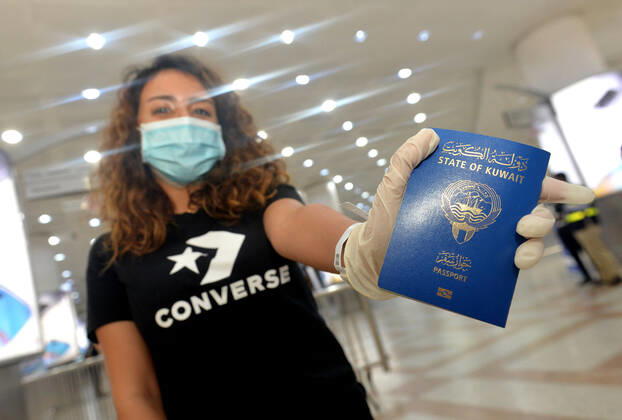 (200419) -- FARWANIYA GOVERNORATE, April 19, 2020 -- A Kuwaiti girl holds her passport after arriving at Kuwait International Airport in Farwaniya Governorate, Kuwait, April 19, 2020. Kuwait launched on Sunday its major airlift to bring home Kuwaitis stranded abroad due to the coronavirus pandemic. (Photo by Xinhua) KUWAIT-FARWANIYA GOVERNORATE-COVID-19-AIRPORT-REPATRIATION Asad 