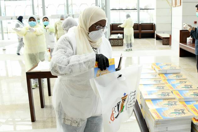 (200419) -- KUWAIT CITY, April 19, 2020 (Xinhua) -- Workers prepare publications to be distributed to quarantined people in the National Library of Kuwait in Kuwait City, Kuwait, April 19, 2020. Kuwaiti National Council for Culture, Arts and Letters (NCCAL), in cooperation with Kuwait Red Crescent Society, prepared on Sunday cultural baskets containing a number of publications to distribute to quarantined people due to the coronavirus for their recreation and leisure time reading. (Photo by Ghazy Qaffaf Xinhua) KUWAIT-KUWAIT CITY-CORONAVIRUS-PUBLICATION DISTRIBUTION 