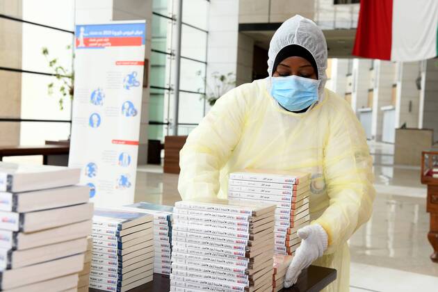 (200419) -- KUWAIT CITY, April 19, 2020 (Xinhua) -- A worker prepares publications to be distributed to quarantined people in the National Library of Kuwait in Kuwait City, Kuwait, April 19, 2020. Kuwaiti National Council for Culture, Arts and Letters (NCCAL), in cooperation with Kuwait Red Crescent Society, prepared on Sunday cultural baskets containing a number of publications to distribute to quarantined people due to the coronavirus for their recreation and leisure time reading. (Photo by Ghazy Qaffaf Xinhua) KUWAIT-KUWAIT CITY-CORONAVIRUS-PUBLICATION DISTRIBUTION 