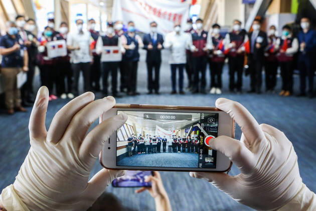 (200419) -- PARANAQUE CITY, April 19, 2020 -- Members of the Chinese Anti-Epidemic Medical Expert Team pose for photos as they prepare to leave Manila for China at the Manila Ninoy Aquino International Airport (NAIA) in Paranaque City, the Philippines, on April 19, 2020. The Philippines on Sunday thanked China anew for its help, saying the crucial medical supplies donated by the Chinese government and the ideas shared by the Chinese experts have provided a lifeline to the Philippines efforts to step up the fight against the COVID-19. Philippine Health Secretary Francisco Duque made the remarks at the seeing-off ceremony held for the 12-member team of Chinese experts, which arrived in Manila on April 5 to share firsthand experiences and best practices with Philippine health officials on how to properly manage the COVID-19 epidemic. 