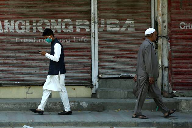 (200419) -- RAWALPINDI, April 19, 2020 -- People walk past a closed shop in Rawalpindi of eastern Pakistan s Punjab province on April 19, 2020. ) PAKISTAN-RAWALPINDI-COVID-19-DAILY LIFE AhmadxKamal 