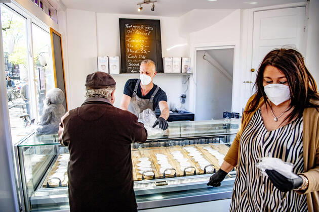 April 19, 2020, Amsterdam, Netherlands: A woman holds masks at the store..Opening a face mask store during the corona crisis is very critical. Certified surgical face masks would be sold for 9 euros each and the store can only take cash. Amsterdam Netherlands - ZUMAs197 20200419_zaa_s197_038 Copyright: xRobinxUtrechtx