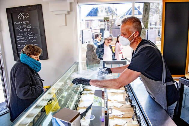 April 19, 2020, Amsterdam, Netherlands: A man gestures while wearing a face mask at the store..Opening a face mask store during the corona crisis is very critical. Certified surgical face masks would be sold for 9 euros each and the store can only take cash. Amsterdam Netherlands - ZUMAs197 20200419_zaa_s197_045 Copyright: xRobinxUtrechtx