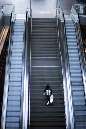 Hauptbahnhof Berlin - Corona-Zeiten DEU, Deutschland, Germany, Berlin, 19.04.2020 Passagier auf der sonst leeren Rolltreppe im Hauptbahnhof Berlin der DB Deutsche Bahn zu Zeiten der Corona-Krise und einer Ausgangssperre. Lonely passanger on an escalator at the otherwise empty railway station of the German railway company DB Deutsche Bahn at the main station Hauptbahnhof in times during the Corona crises and a lookout in Berlin, Germany.