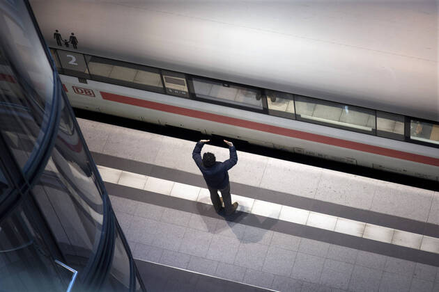 Hauptbahnhof Berlin - Corona-Zeiten DEU, Deutschland, Germany, Berlin, 19.04.2020 Mann verabschiedet einen Passagier im sonst leeren Hauptbahnhof Berlin der DB Deutsche Bahn zu Zeiten der Corona-Krise und einer Ausgangssperre. Lonely passanger at the otherwise empty railway station of the German railway company DB Deutsche Bahn at the main station Hauptbahnhof in times during the Corona crises and a lookout in Berlin, Germany.