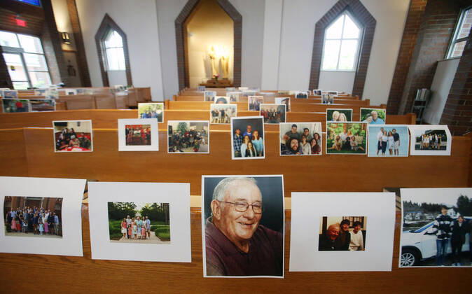 Photos of parishioners wait for the start of Rev. Bob Evans Sunday service at the Holy Spirit Catholic Church in Maryland Heights, Missouri on Sunday, April 19, 2020. Since members cannot attend in person because of the Coronavirus pandemic, Evans asked for his church to send in photos of themselves receiving over 500 photos from his 1500 membership. The photos are taped to the pews where the family sits, while he preforms the weekly service via Facebook live.  SLP2020041912 BILLxGREENBLATT