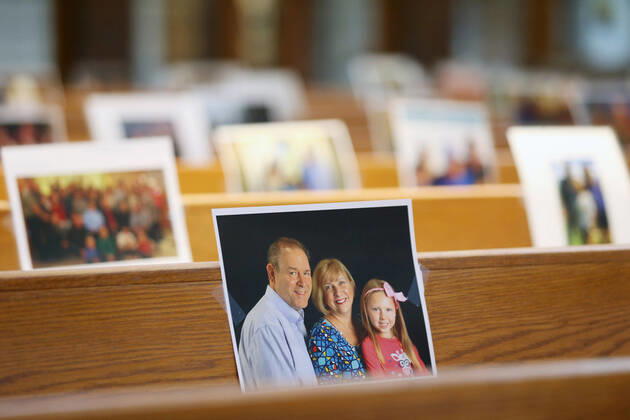 Photos of parishioners wait for the start of Rev. Bob Evans Sunday service at the Holy Spirit Catholic Church in Maryland Heights, Missouri on Sunday, April 19, 2020. Since members cannot attend in person because of the Coronavirus pandemic, Evans asked for his church to send in photos of themselves receiving over 500 photos from his 1500 membership. The photos are taped to the pews where the family sits, while he preforms the weekly service via Facebook live.  SLP2020041914 BILLxGREENBLATT