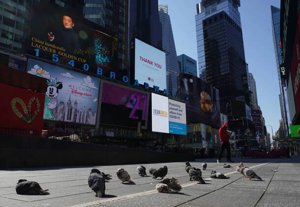 A pedestrian wearing a protective face walks in a nearly empty of pedestrian and automobile traffic Times Square on Easter Sunday of Orthodox Easter weekend in New York City on Sunday, April 19, 2020. The world s Orthodox Christians are celebrating Easter through a series of restrictions and bans including closures of churches due to the Coronavirus pandemic. More than 13,300 people with COVID-19 have died in New York State.  NYP20200419110 JOHNxANGELILLO
