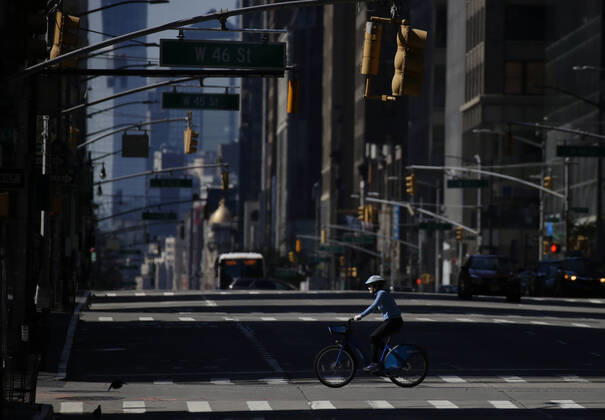 A biker wearing a protective face mask crosses a nearly empty 5th Avenue on Easter Sunday of Orthodox Easter weekend in New York City on Sunday, April 19, 2020. The world s Orthodox Christians are celebrating Easter through a series of restrictions and bans including closures of churches due to the Coronavirus pandemic. More than 13,300 people with COVID-19 have died in New York State.  NYP20200419113 JOHNxANGELILLO