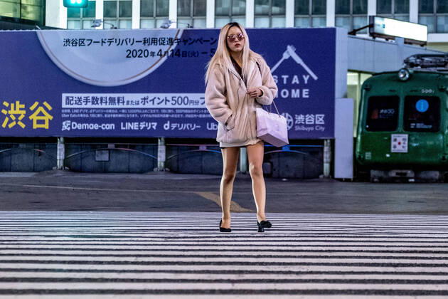 April 19, 2020, Tokyo, Japan: A woman crosses the street with lights off and restaurants closed in Shibuya area during the covid-19 crisis..The Japan government declared a state of emergency to cover the whole country and will continue until May 6. Tokyo governor, Yuriko Koike has asked restaurants and bars to be closed at 8pm as a preventive measure against COVID-2019. Tokyo Japan - ZUMAs197 20200419_zaa_s197_072 Copyright: xViolaxKamx