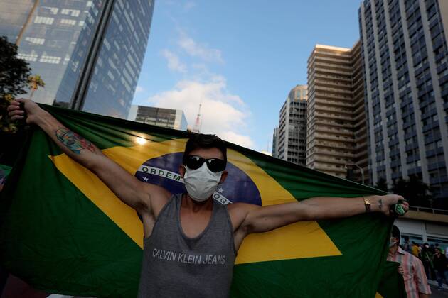 A man with a facial mask waves a Brazilian flag during a demonstration against social isolation and in favor of military intervention, on Paulista Avenue, in Sao Paulo, Brazil, 19 April 2020. The President of Brazil, Jair Bolsonaro, once again ignored the health recommendations for social distancing amid the coronavirus pandemic and took part this Sunday in one of the several demonstrations that were held in his favor in different cities of the country. Bolsonaro spoke in Brasilia before hundreds of sympathizers who gathered outside the Army Headquarters to request a military intervention. Bolsonaro ignores recommendations and takes part in a day of demonstrations !ACHTUNG: NUR REDAKTIONELLE NUTZUNG!  Copyright: xFernandoxBizerrax AME3885 20200419-637229367031613517